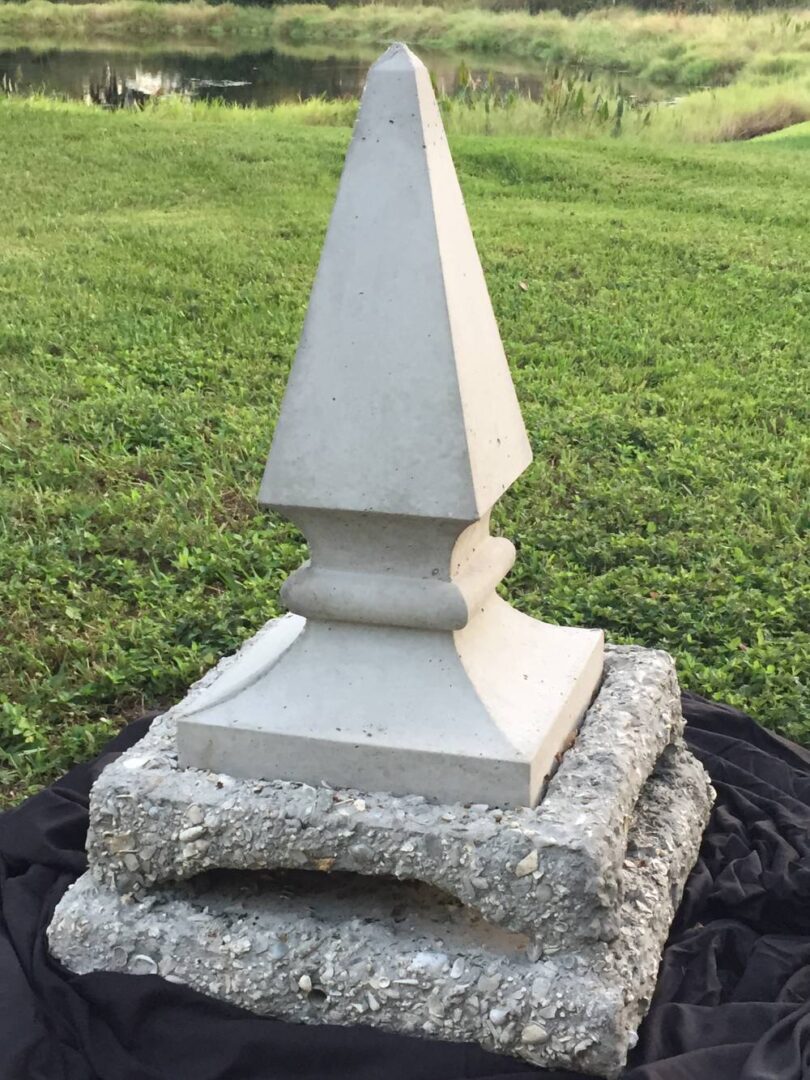 A stone statue sitting on top of a cement block.